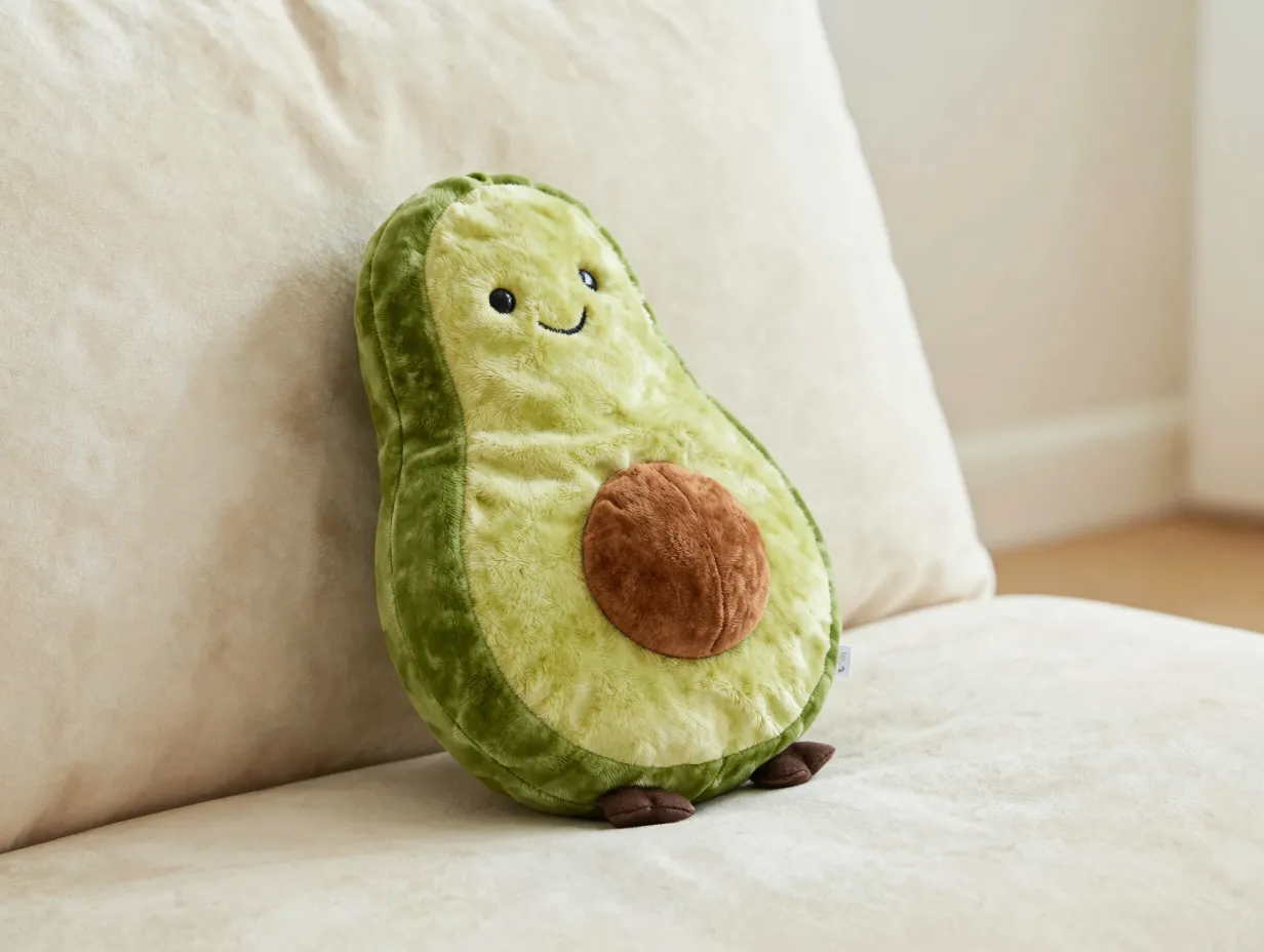 Soft green velvet avocado squeaky toy on a cream velvet cushion